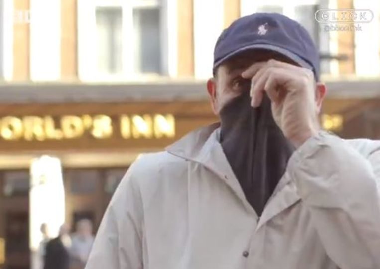 De voorbijganger verborg zijn gezicht in zijn trui.